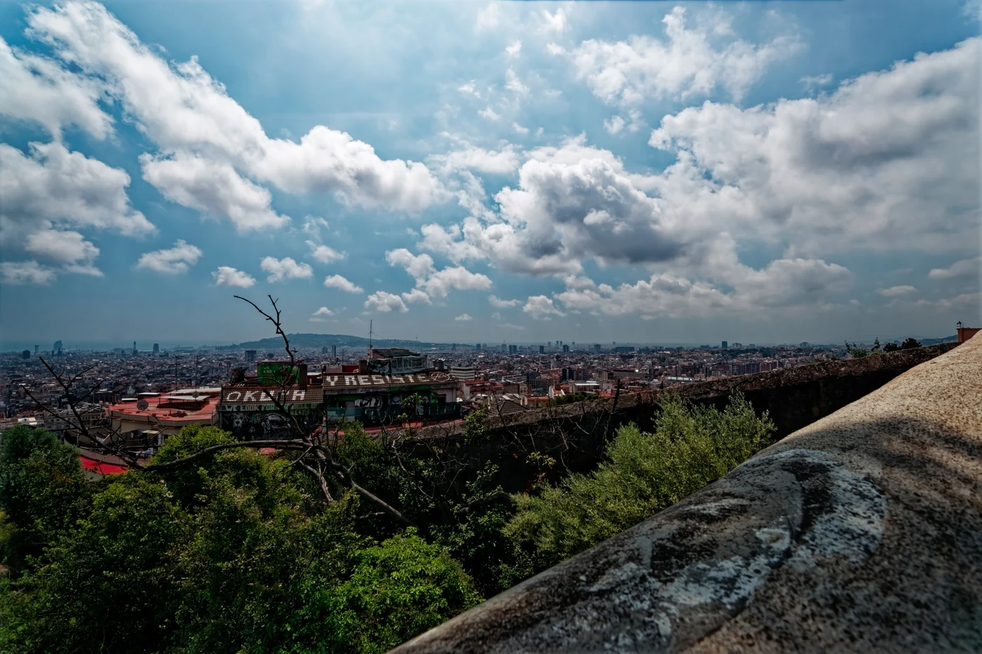 Barcelona seen from Park Güell, with a mosaic bench in the foreground.